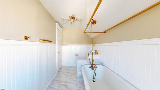 bathroom featuring a bath and vaulted ceiling