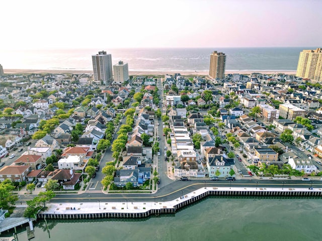 aerial view at dusk featuring a water view