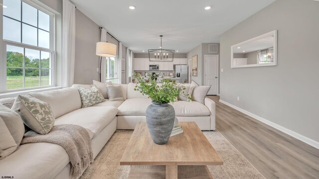 living room with a notable chandelier and light hardwood / wood-style floors