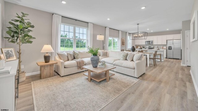 living room featuring a chandelier and light hardwood / wood-style flooring