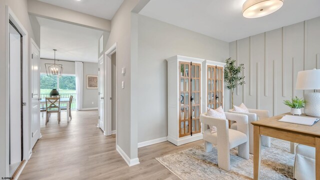 office area with an inviting chandelier and light hardwood / wood-style floors