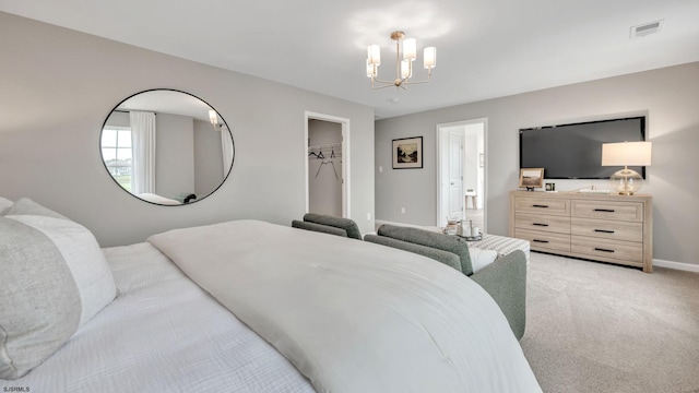 carpeted bedroom with an inviting chandelier and a walk in closet