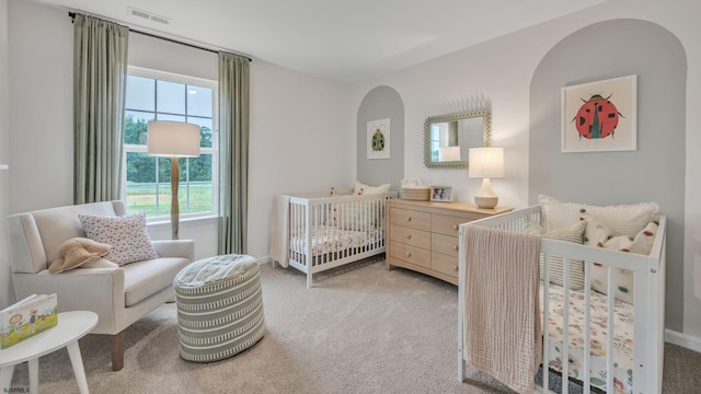 carpeted bedroom with a crib