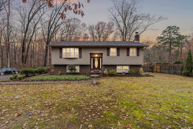 split foyer home featuring a lawn