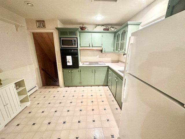 kitchen featuring green cabinets, white appliances, and a baseboard heating unit