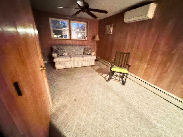 sitting room featuring ceiling fan, an AC wall unit, baseboard heating, and carpet floors