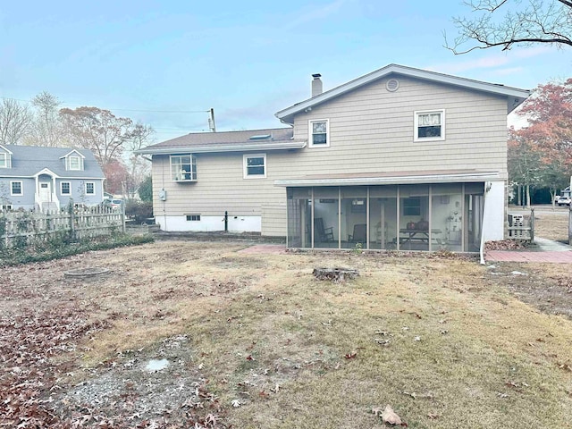 rear view of property with a sunroom and a yard