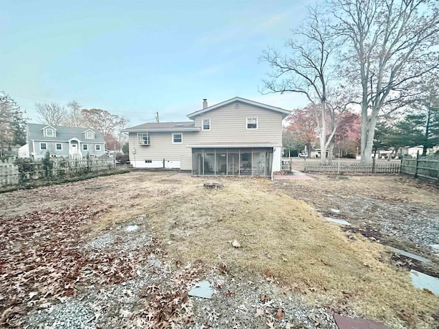 rear view of property featuring a sunroom and a yard