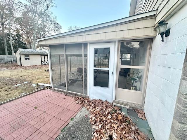 view of patio / terrace with a sunroom and a shed