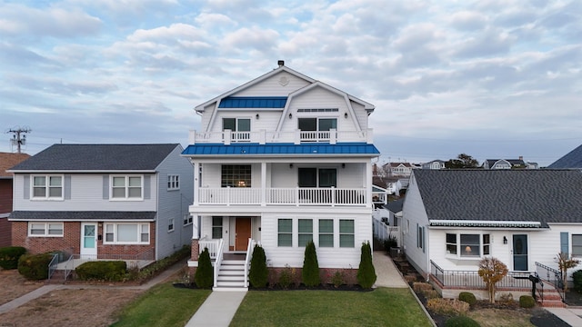 view of front of property with a front yard and a balcony