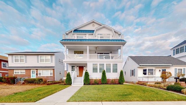 view of front facade with a balcony and a front yard