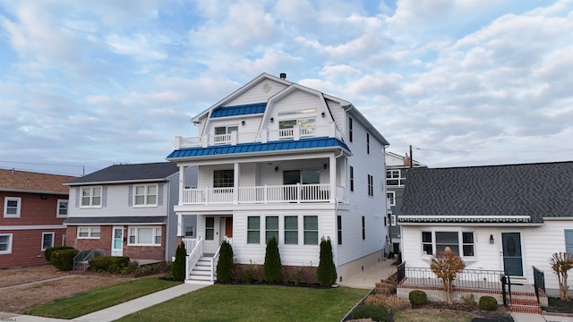 view of front of home featuring a balcony and a front lawn