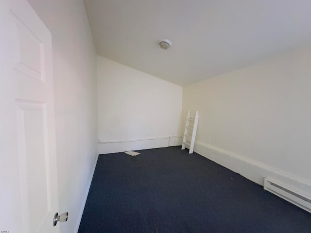 empty room featuring carpet and a baseboard heating unit