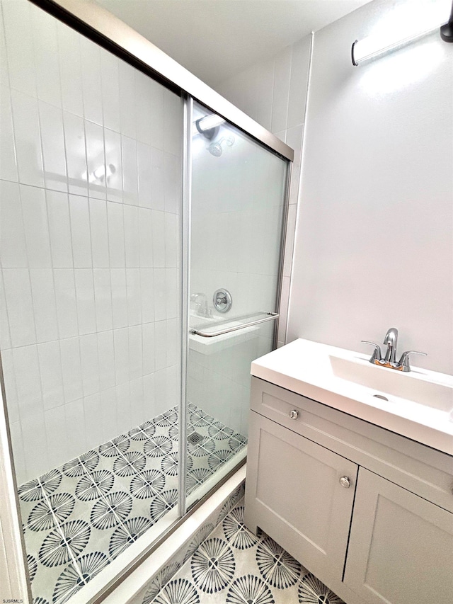 bathroom featuring tile patterned floors, an enclosed shower, and sink