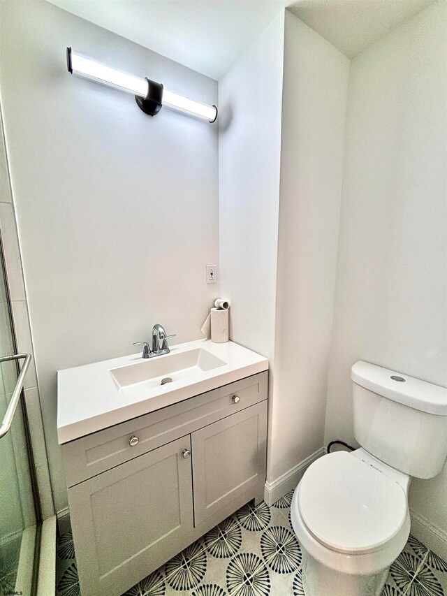 bathroom with tile patterned flooring, vanity, and toilet