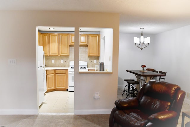 kitchen featuring pendant lighting, white appliances, decorative backsplash, light brown cabinetry, and a chandelier