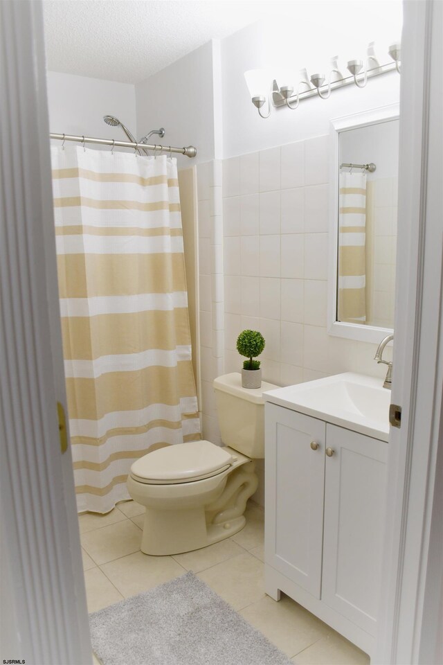 bathroom featuring tile patterned floors, a textured ceiling, toilet, vanity, and a shower with shower curtain