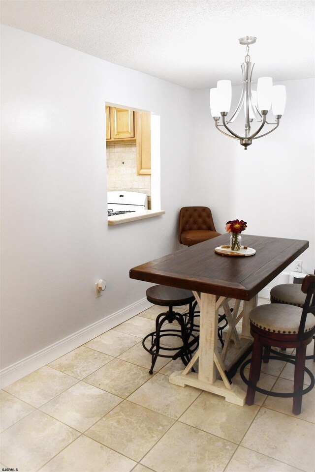 dining area featuring light tile patterned flooring and a chandelier