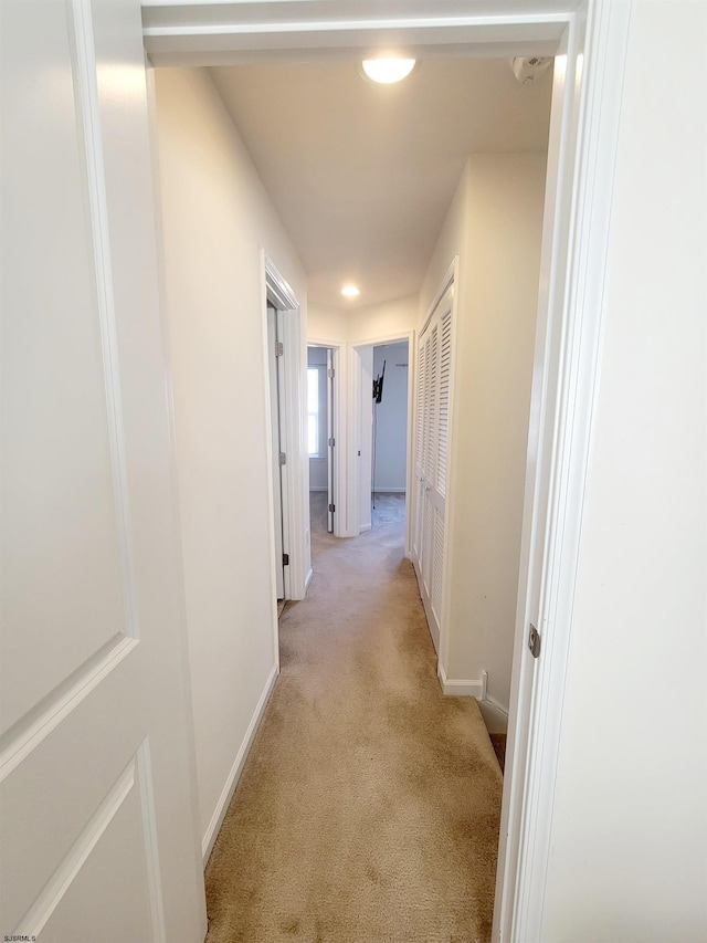 hallway featuring light colored carpet