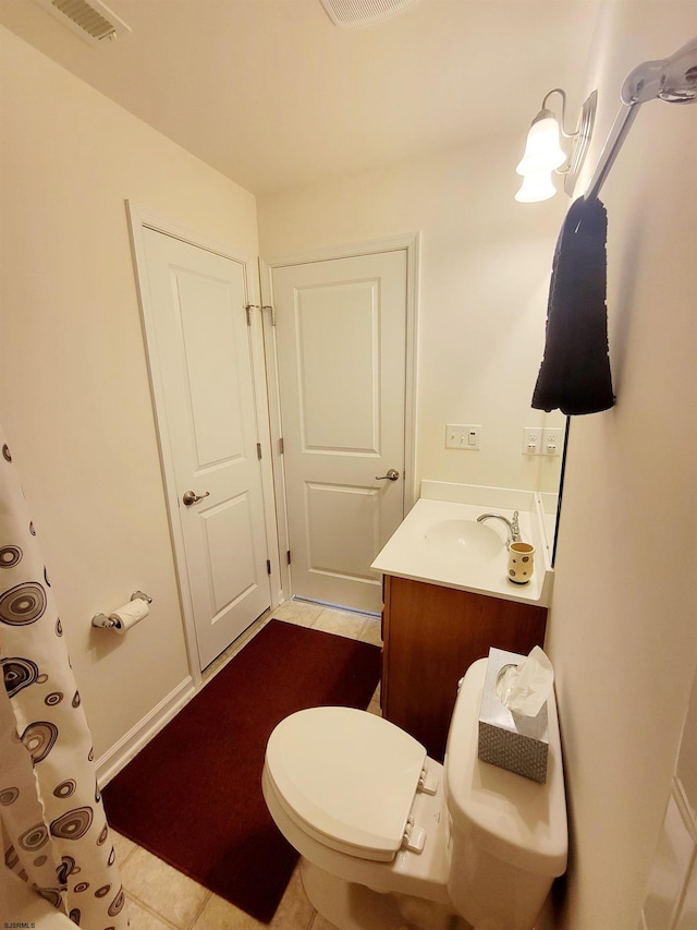 bathroom with tile patterned flooring, vanity, and toilet