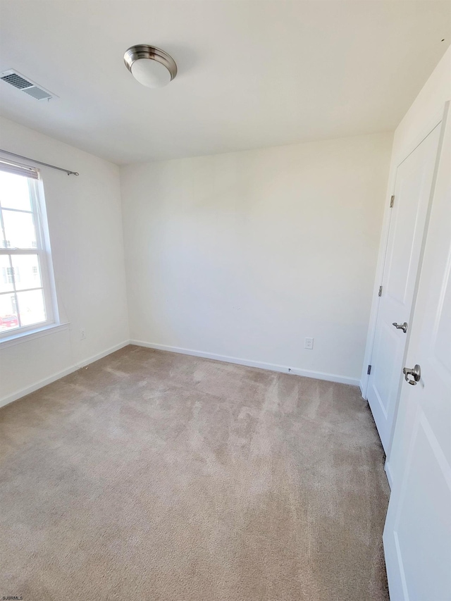 unfurnished room featuring light colored carpet