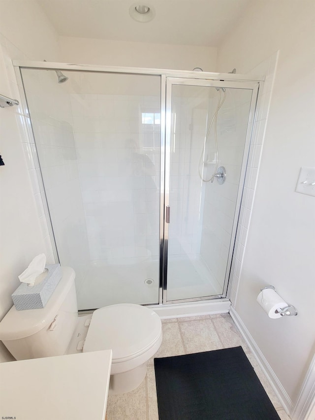 bathroom with an enclosed shower, toilet, and tile patterned floors