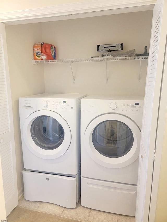 laundry area featuring separate washer and dryer and light tile patterned floors