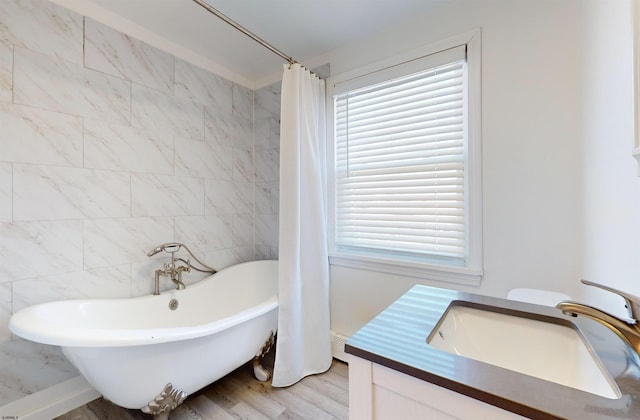 full bathroom featuring sink, plus walk in shower, toilet, tile walls, and hardwood / wood-style flooring