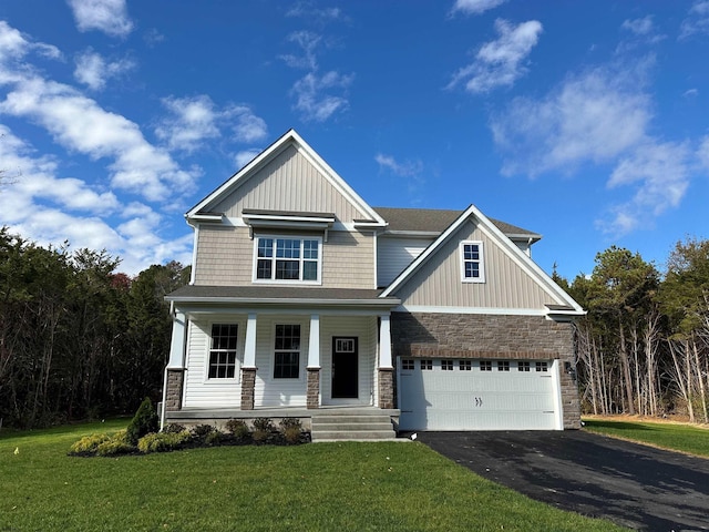 craftsman-style house featuring a porch, a front yard, and a garage