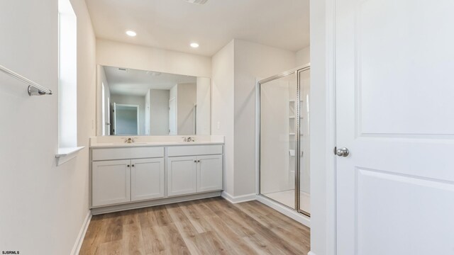 bathroom with vanity, hardwood / wood-style flooring, and a shower with shower door