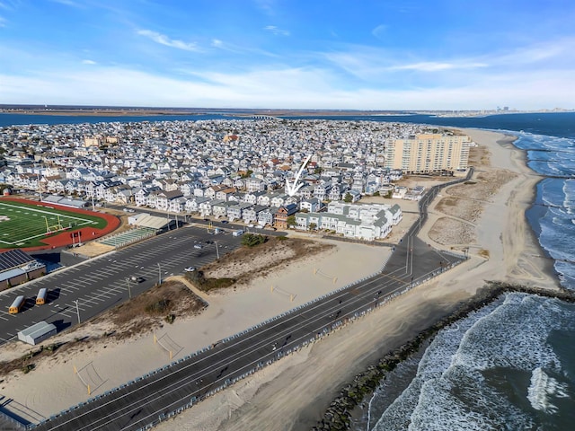 birds eye view of property featuring a water view and a beach view