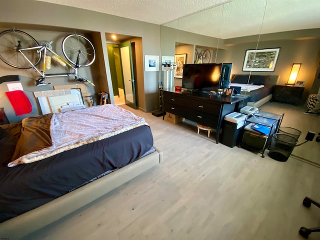 bedroom featuring a textured ceiling and light hardwood / wood-style flooring