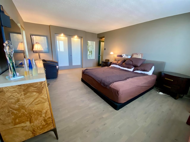 bedroom with wood-type flooring and a textured ceiling