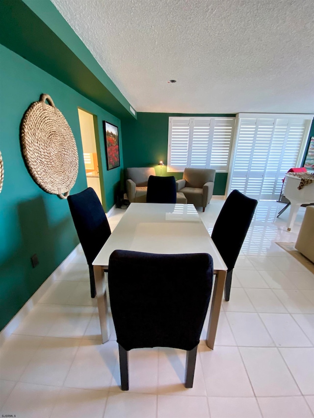 tiled dining room with a textured ceiling