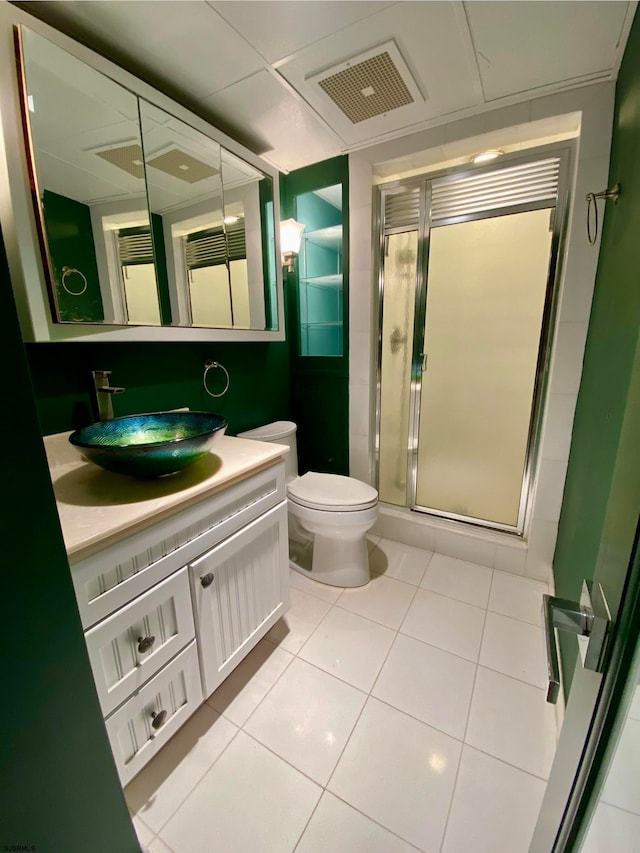 bathroom with tile patterned flooring, vanity, an enclosed shower, and toilet