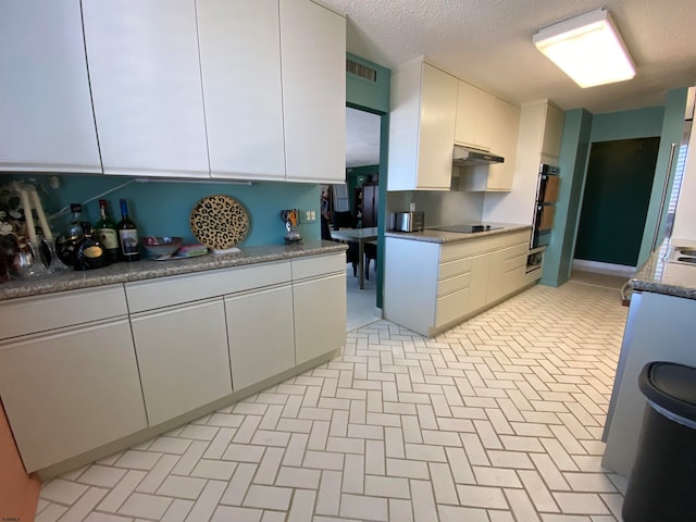 kitchen with white cabinets, a textured ceiling, and black appliances