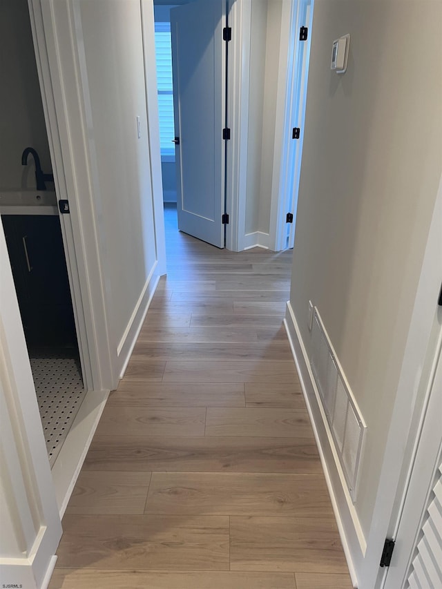 hall with sink and light hardwood / wood-style floors