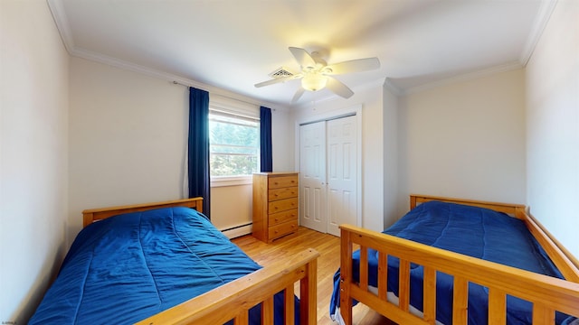 bedroom featuring hardwood / wood-style floors, ceiling fan, ornamental molding, and a closet