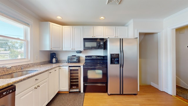 kitchen featuring black appliances, light stone countertops, light wood-type flooring, white cabinetry, and beverage cooler