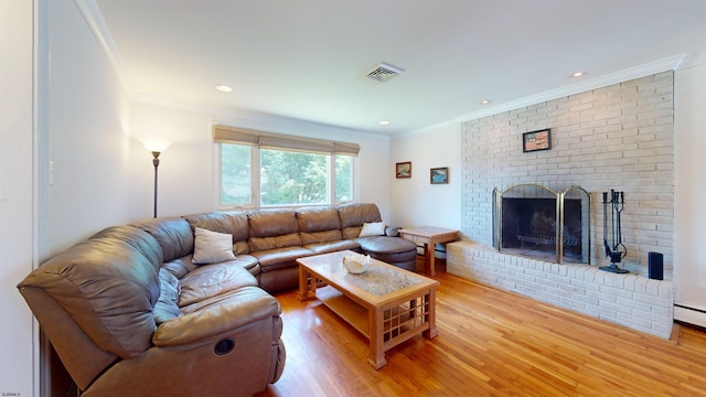 living room featuring a brick fireplace, crown molding, and light wood-type flooring