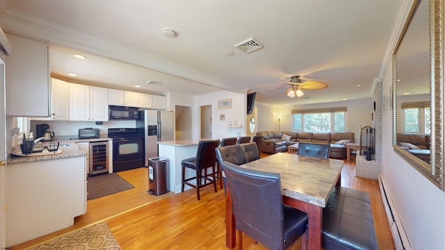 dining room featuring crown molding, wine cooler, ceiling fan, light wood-type flooring, and baseboard heating