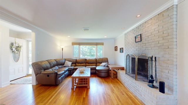 living room featuring a fireplace, light hardwood / wood-style floors, and ornamental molding