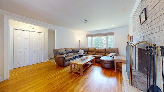 living room featuring a fireplace, wood-type flooring, and ornamental molding