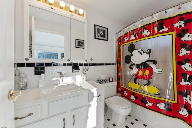 bathroom with tile patterned flooring, vanity, tile walls, and toilet