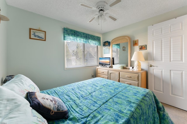 bedroom with light carpet, a textured ceiling, and ceiling fan