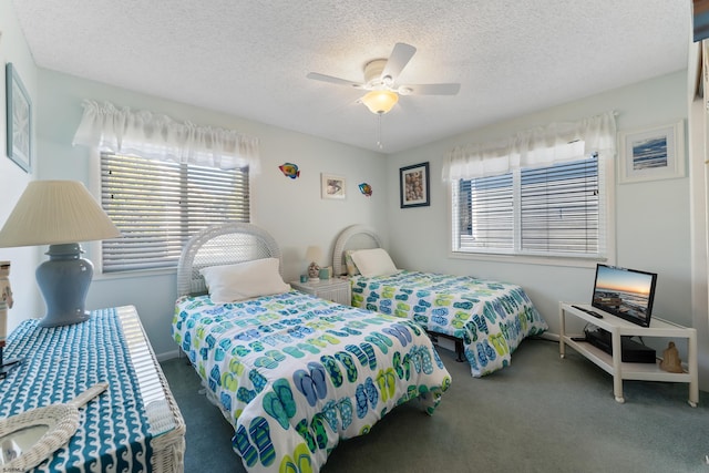 carpeted bedroom featuring ceiling fan and a textured ceiling