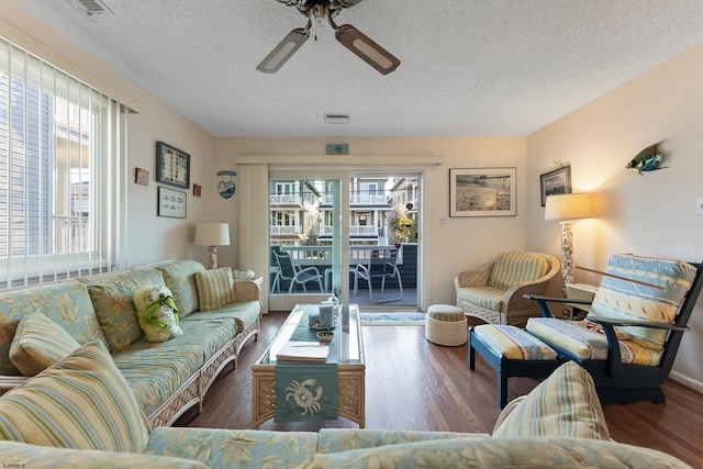 living room featuring a textured ceiling, hardwood / wood-style flooring, and ceiling fan