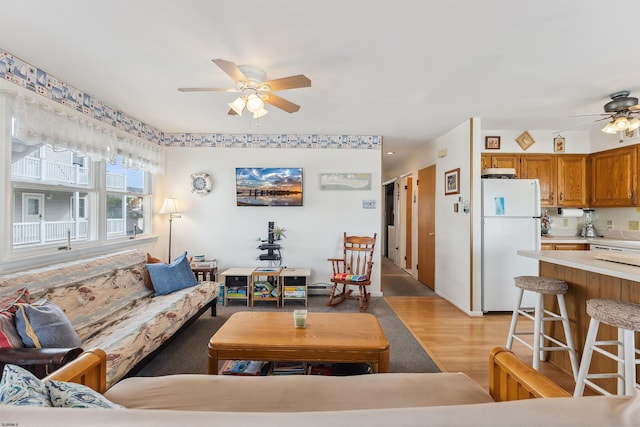 living room featuring ceiling fan and light hardwood / wood-style floors