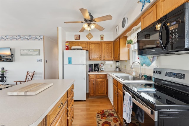 kitchen featuring ceiling fan, white appliances, light hardwood / wood-style floors, and sink