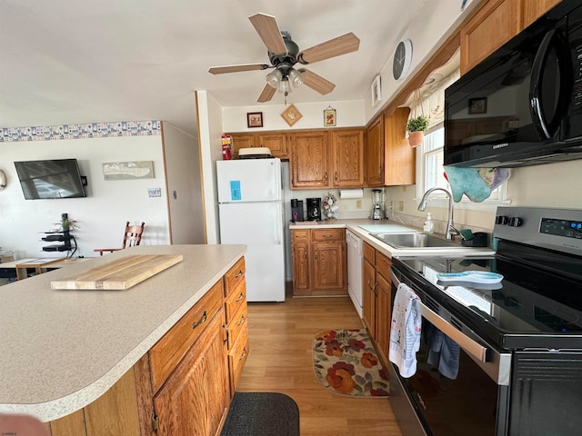 kitchen featuring sink, white appliances, light hardwood / wood-style flooring, a kitchen island, and ceiling fan